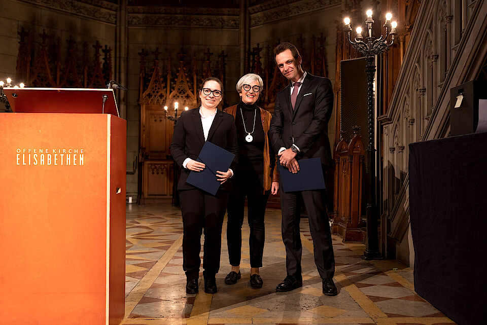 Foto der Preisverleihung des Professor Walther Hug-Preis für die besten Dissertationen: Prof. Dr. Regula Kägi-Diener übergibt den Preis an Frau Dr. Katharina Zimmermann und Herrn Dr. Yannick Hostettler.