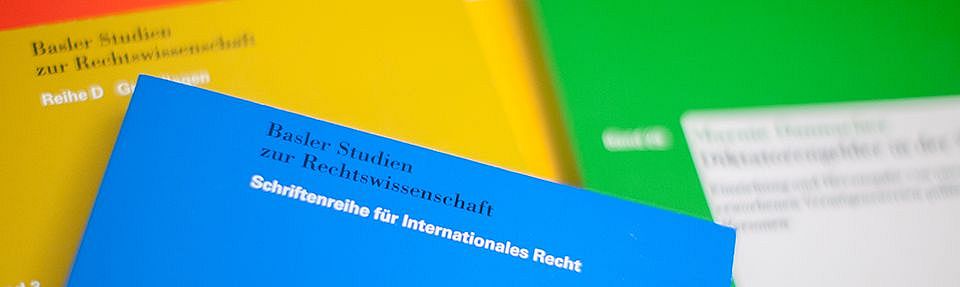 Picture with different colored dissertations lying on top of each other.