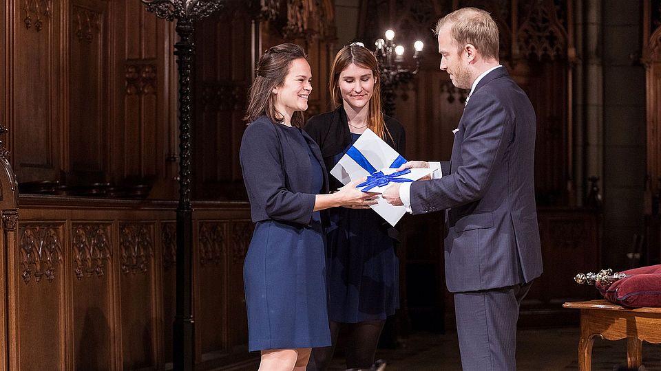 Bild der Verleihung des "böckli bühler partner-Preises" für den besten Bachelorabschluss im Jahre 2018 durch Dr. iur. Daniel Häring im Rahmen der Promotionsfeier an Fiona Zilian und Nathalie Glaser.