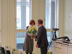 Szene der Veranstaltung Rousseau Lectures 2023 im Auditorium der Juristischen Fakultät mit Blumenübergabe an eine Sprecherin.