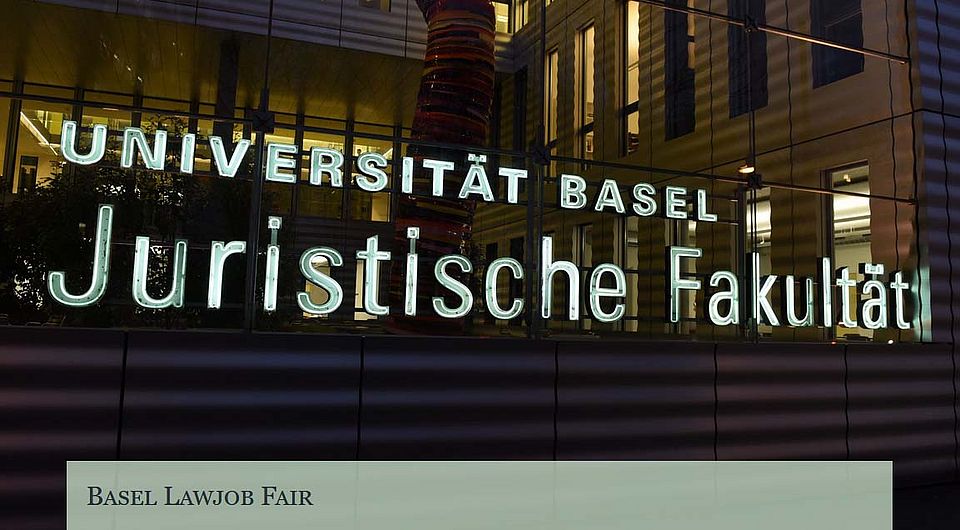 Rückansicht der Juristischen Fakultät bei Nacht, von der Nauenstrasse her mit dem beleuchteten Schriftzug der Fakultät im Fokus.