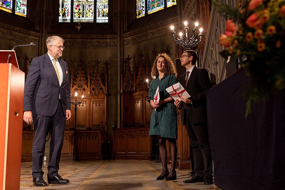 Foto mit Liliane Obrecht und Cyrill Chevalley, die den böckli bühler partner-Preis für den besten Masterabschluss des Jahres 2022 von Rechtsanwalt Jan Bangert überreicht bekommen.