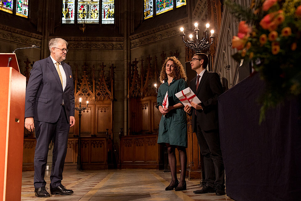 Foto mit Liliane Obrecht und Cyrill Chevalley, die den böckli bühler partner-Preis für den besten Masterabschluss des Jahres 2022 von Rechtsanwalt Jan Bangert überreicht bekommen.