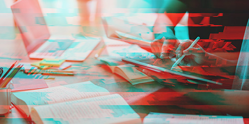 Symbolbild für den Bereich Gutachten/Beratung mit einer Schreibtisch-Arbeitssituation (aufgeschlagenes Buch und Laptop links und rechts zwei Personen, von denen eine ein Tablet hält und die andere darauf zeigt) in rot-blauer Optik.